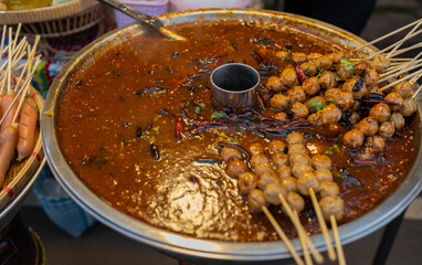 Grilled meatballs dipped in a hot saucepan to enhance the delicious taste of the food. This type of cooking is commonly found in street food.