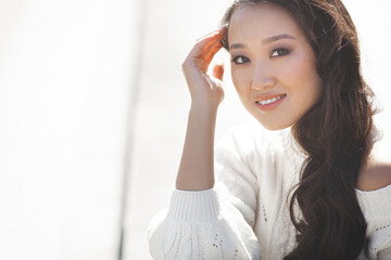 Beautiful woman outdoors. Pretty lady on urban background. Asian female closeup portrait.