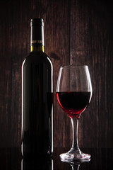 wine glass with red wine on wooden table