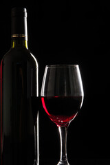 wine glass with red wine on black background