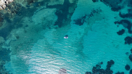 Top view of a lonely boat in a paradisiac sea