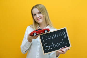 beautiful smiling young woman with a car in her hand. The concept of learning in a driving school and buying a new car.