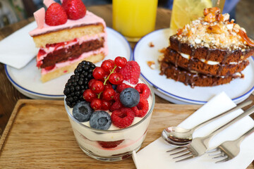 summer desserts with berries in a glass bowl and large glasses of homemade lemonade on a wooden  in a cafe