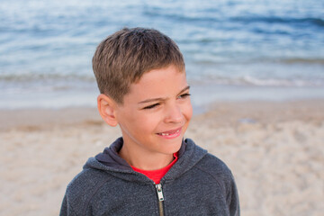 boy smiling on the beach in raglan in the evening