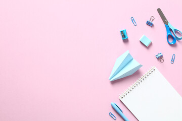 Back to school creative layout. Flat lay blue school supplies on pink table.