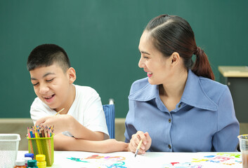 Teacher smiling with disable children or Autism childs who  are down syndrome to painting color on...
