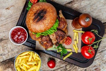 Street food, Hands holding fresh delicious burgers with french fries, sauce and beer on the wooden background, burgers for a restaurant menu