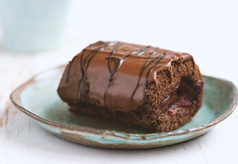 Chocolate cake with blackcurrant in ceramic plate on white wooden background.close up