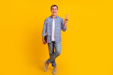 Photo of a cheerful caucasian smart young man holding laptop smiling make v-sign isolated bright color background