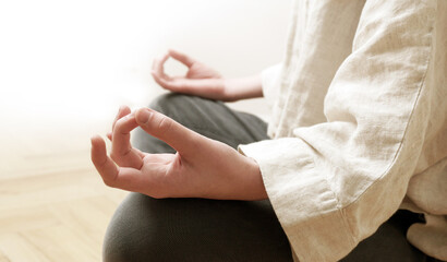 Young woman with gyan mudra hand practicing meditation at home. Harmony, self care, breathing...