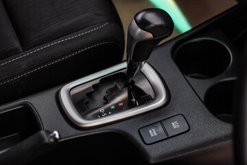 Obraz na płótnie Canvas automatic transmission shift selector in the car interior. Closeup a manual shift of modern car gear shifter. 4x4 gear shift