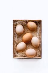 Eggs with hay in wooden box on rustic fabric. Top view food composition. Chicken eggs. Easter concept with copy space for text.Top view