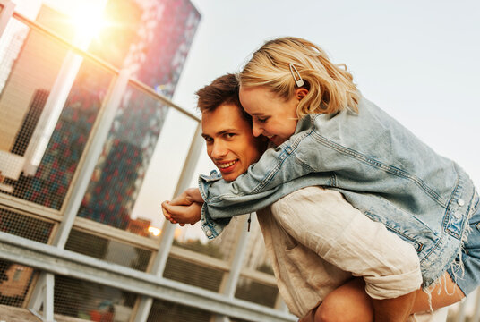 summer holidays, love and people concept - happy young couple having fun on roof top parking