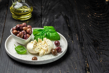 Creamy Italian Burrata Cheese with basil and olive oil on white plate. Italian Mediterranean cuisine. banner, menu, recipe place for text, top view