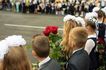 Knowledge Day in Russia. Children with flowers. First graders on September 1. Students in front of...