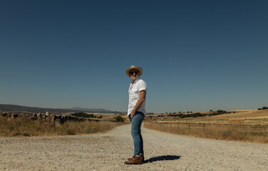 Adult man in cowboy hat on dirt road against sky. Castilla y Leon, Spain