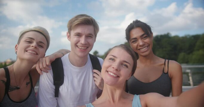 Group of multiracial people takes photo smiling against sky