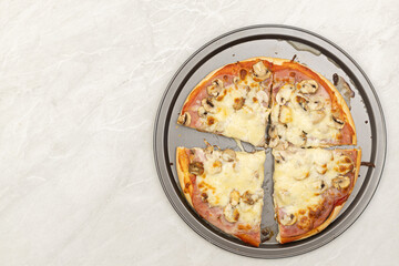 Top view of baked pizza with ketchup ham cheese and mushrooms