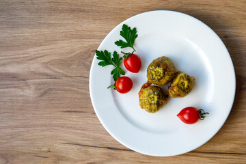 Traditional delicious Turkish - Greek cuisine, Turkish food Stuffed zucchini flowers (Turkish name kabak cicegi dolmasi) on white plate. Top view flat lay, copy space