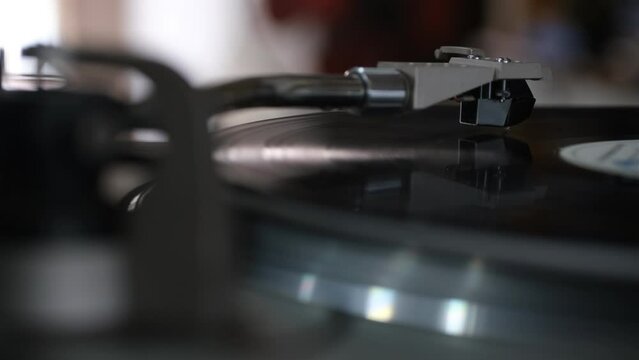 Focus on The Headshell Cartridge and Stylus of Classic Vintage Vinyl Record Player from behind and Playing on Vinyl Record Music