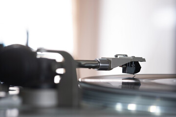 Fototapeta na wymiar Focus on The Headshell Cartridge and Stylus of Classic Vintage Vinyl Record Player Playing on Vinyl Record Music