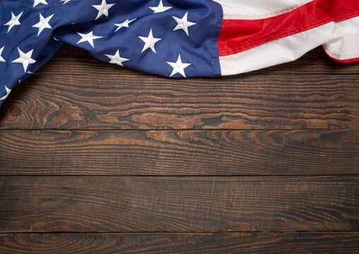 Flat lay USA flag on brown wooden board, vintage background with copy space top view. Banner, minimalism, loft style. American