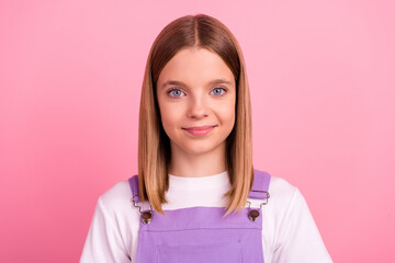 Portrait of young charming pretty girl in violet overall and short bob hairstyle isolated on pink...