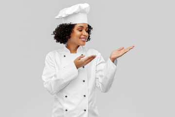 cooking, advertisement and people concept - happy smiling female chef in white jacket holding...