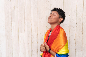 Obraz na płótnie Canvas LGBTQIA woman wrapped in rainbow flag