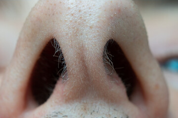 Caucasian male open nasal nostrils macro close up shot. Short nasal hairs, low angle view,...
