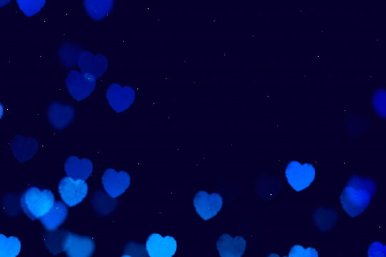 Bokeh festive leack  blue heart symbol on dark  background 