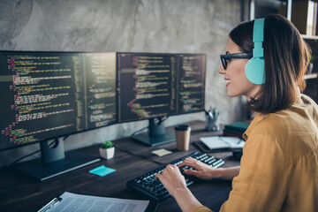 Profile side view portrait of attractive cheery focused girl editing source html binary css at workplace workstation indoors