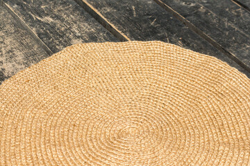 Fototapeta na wymiar handmade rug made of jute lies on the black wooden floor. closeup.