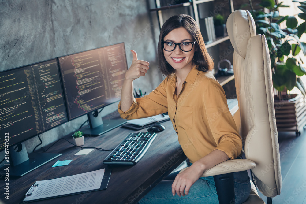 Poster portrait of attractive cheerful girl editing database developing web project showing thumbup at work