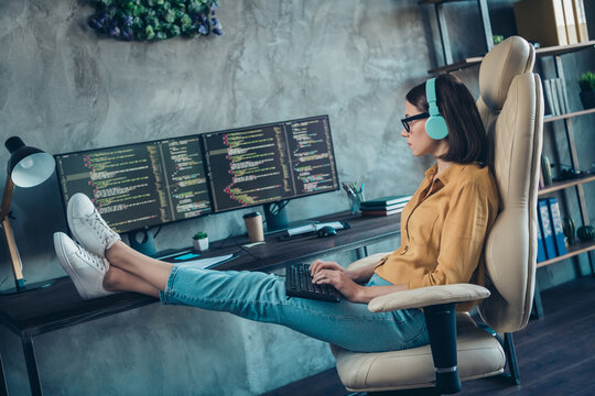 Profile side view portrait of attractive focused girl editor writing new solution php legs on desktop at workplace workstation indoors
