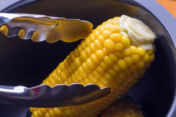 電気調理器の内釜および蒸したトウモロコシ
