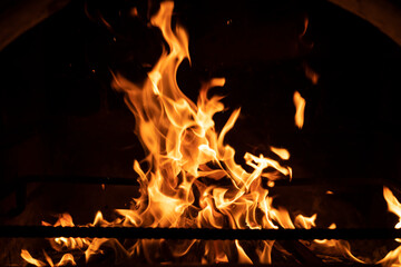 Fire flame in the fireplace. Tongues of flame on a black background. High quality photo