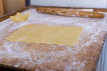 Rolling pin and homemade pastry dough, bakery flour on table. Domestic bread pastry cooking