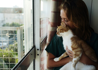 Portrait of teen girl with cat at home - 516749851