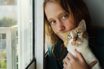 Portrait of teen girl with cat at home - 516749866