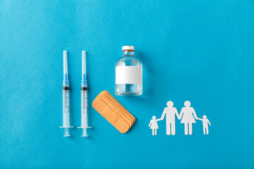 medicine, vaccination and healthcare concept - disposable syringes and family pictogram on blue background