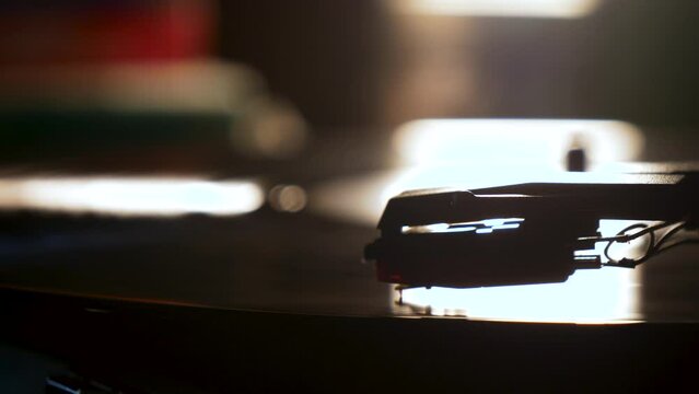 Stylus needle on a vinyl record player with good lighting in the background.