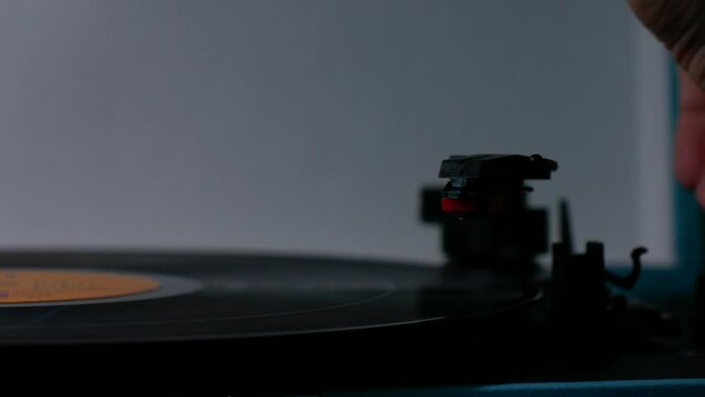 Stylus needle slowly being lowered onto vinyl record.