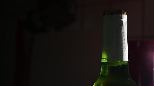 Using a bottle opener to remove a beer cap.