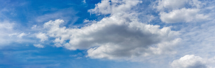 White cumulus clouds in a blue sky in sunny weather