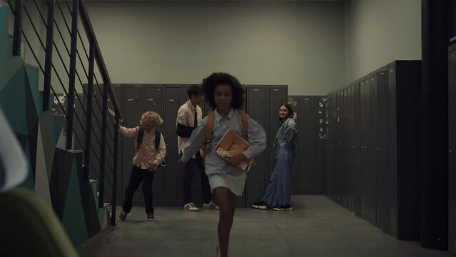 School girl running downstairs on break. African american child sitting bench.