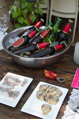 beer bottles on a metallic bowl and fish snacks on rectangle plates at a party