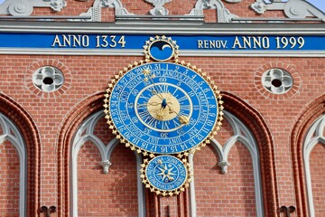 Obraz premium Decoration on the facade of Black Heads house in Riga, Latvia. Medieval astronomical calendar clock with blue dial and gold hands