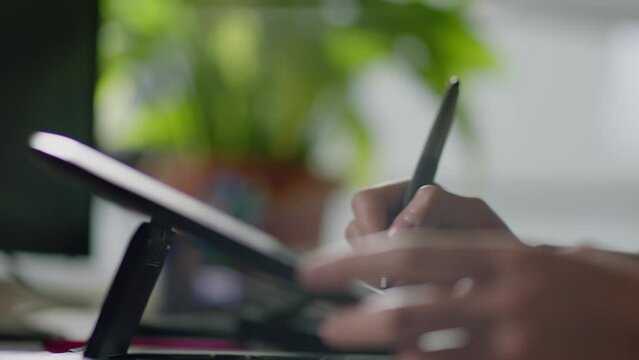 A woman's hand is painting on a tablet. Wireless technology