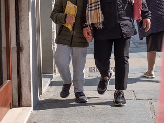 Detail of a Parent holding Hands with his son Walking Down a City Street